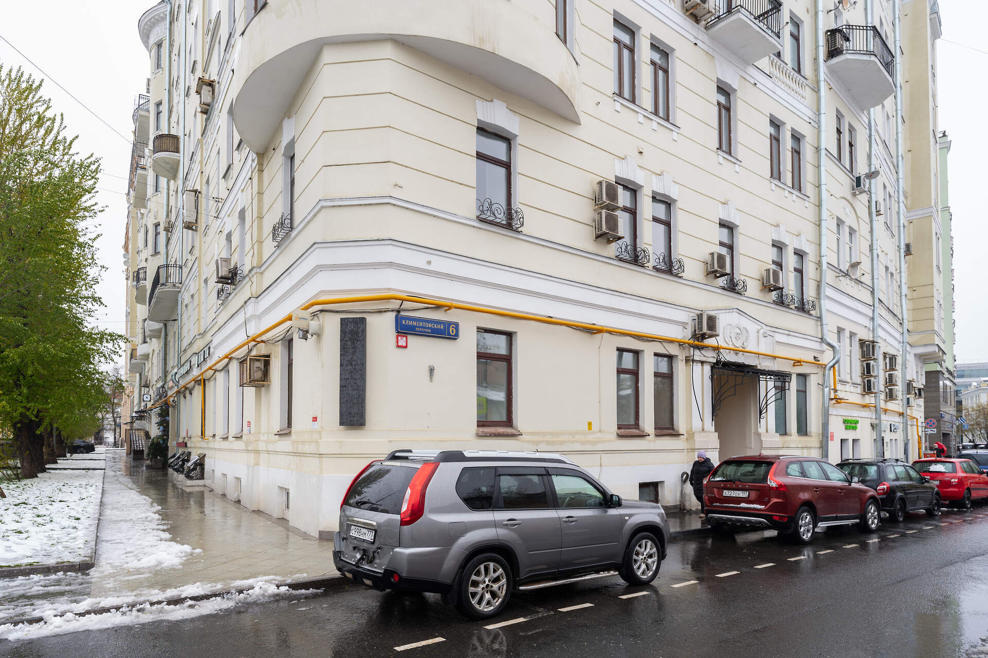 Угловой фасад дома на Климентовском переулке, 6; вдоль улицы припаркованы автомобили.
