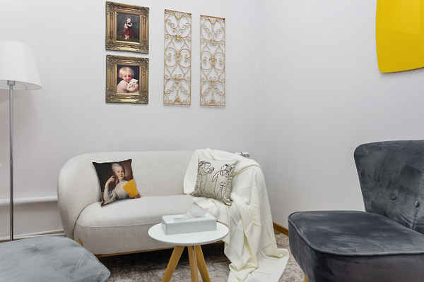 Small room with soft armchairs and paintings on the walls